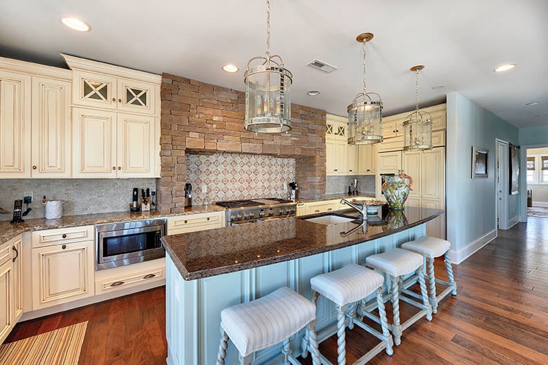 large kitchen with brick accent to white kitchen cabinets