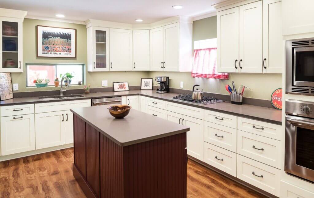 white kitchen cabinets with black hardware and brown island