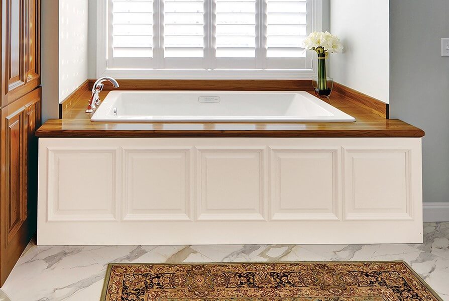 bathtub with white wainscot panel on the bottom and wooden accents