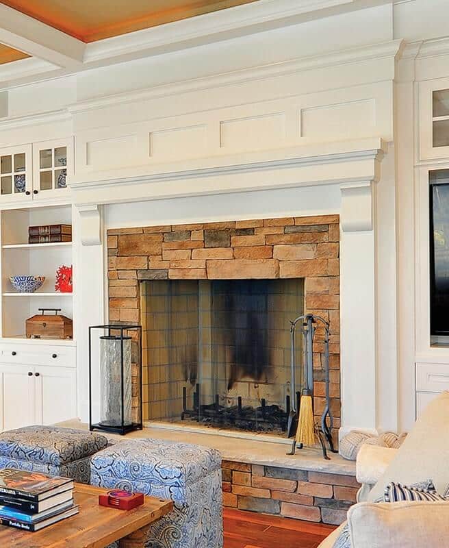 living room with brick fireplace and white wainscot panels