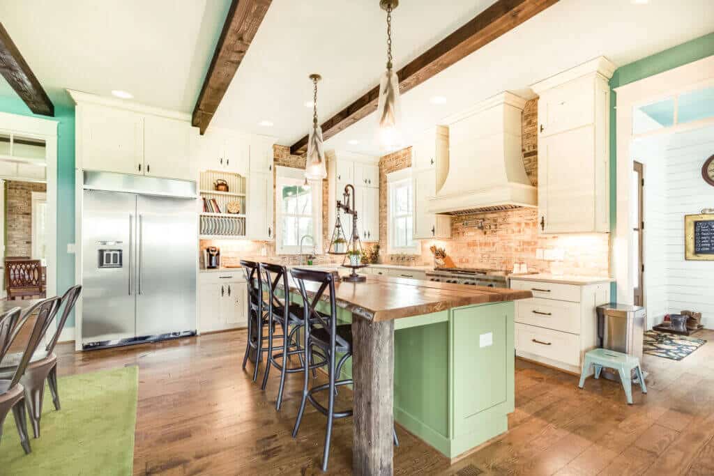 kitchen with white cabinets and brick and green accents